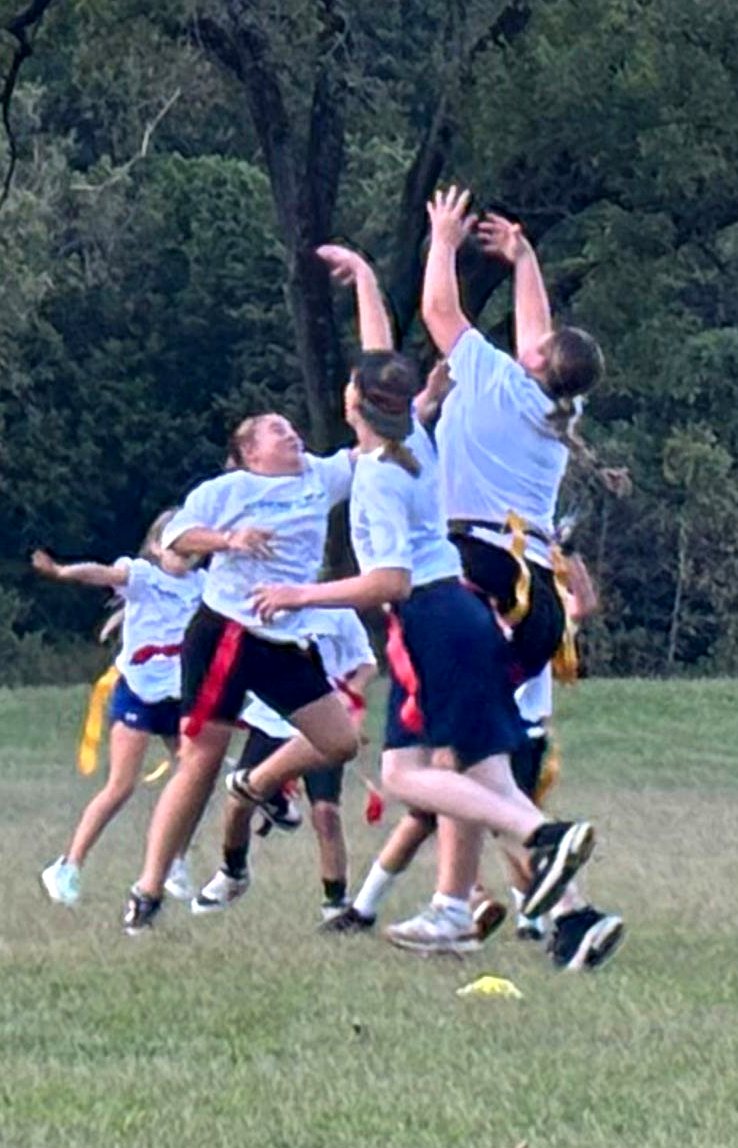 Kids jumping for a pass in flag football